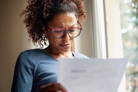 Image of a woman reading a piece of paper